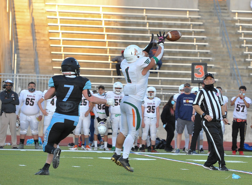 Adams City linebacker Gerardo Caldera picks off a pass intended for Mountain Range wide receiver Connor Hinkle, left, during the second quarter of an April 2 game at District 12 North Stadium in Westminster. The Eagles rallied from a 21-7 deficit to edge the Mustangs, 22-21.